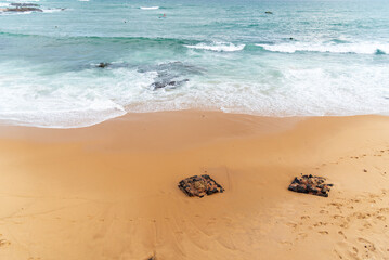 A shot of rocks in the sand of the Rio Vermelho beach in Salvador, Bahia, Brazil.