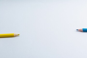 Top view of blue and yellow wooden pencils isolated on white background with copyspace