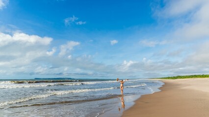 An adult woman in a bikini walking under strong sunlight on beac