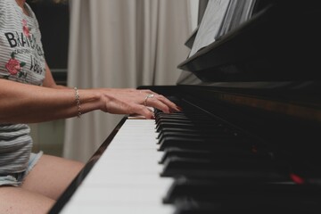 Brazilian pianist woman touching piano keys, playing upright piano. Concept music teaching and arts.