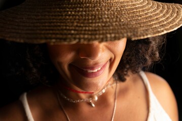 Portrait of a beautiful woman wearing a hat against black background