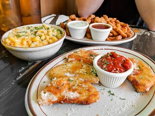 two plates of chicken nuggies, mashed potatoes, salad, and french