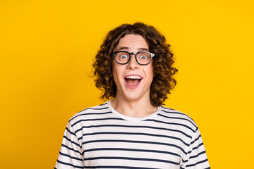 Portrait of young curly hair student guy wearing striped stylish t shirt open mouth impressed...