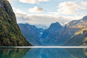 Scenic view of a fjord near Briksdal Glacier under blue cloudy sky in autumn, Norway - Powered by Adobe