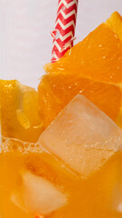 Lemonade pours into a glass with ice and a slice of orange, drink photography