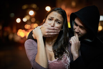 Woman, criminal and hand on mouth with fear for violence, danger and robbery in city at night with bokeh. People, portrait and silence emoji with terror, crime and stalker for kidnapping and hostage - obrazy, fototapety, plakaty