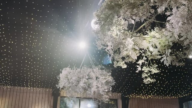  a beam of light from a spotlight illuminates a decorated banquet hall