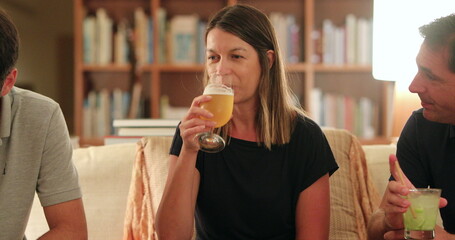 Candid woman holding glass of beer with friends together, woman nodding yes