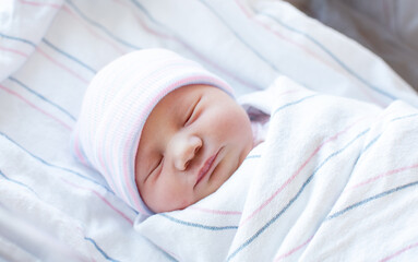 Portrait of Just born Caucasian newborn baby in a hospital outfit. Close-up of the face of the...