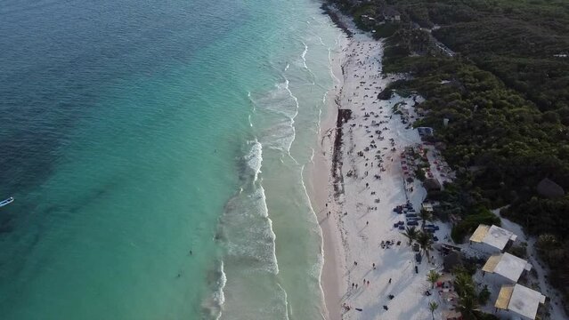 Aerial view of the sunny Tulum Main Beach with green forests