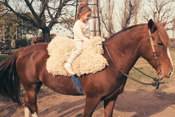 Little girl on a brown horse
