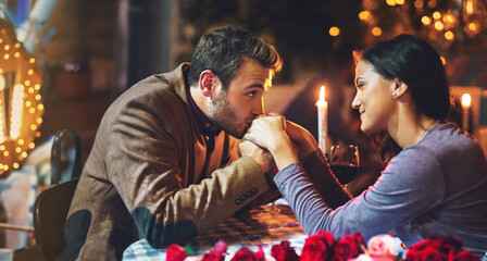 Couple, dinner and date in restaurant for romance with hand kiss, candle or commitment to...