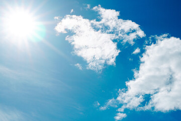 澄み切った晴天の青空に輝く太陽と白い雲　