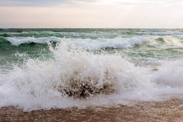 waves crashing the shore. stormy seascape in morning light - 776050525