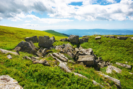 green alpine hills and meadow of carpathians. stones among the grass beneath a sky with clouds. summer vacations in ukrainian mountains