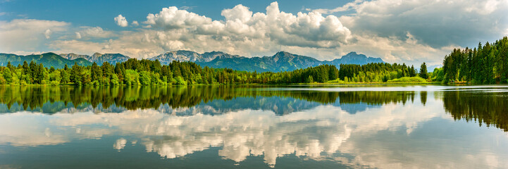 Panoramic photo of rural landscape with reflection in lake in the Allgäu in Bavaria
