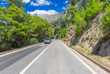 Fototapeta premium Country road with rocky mountains in the background.