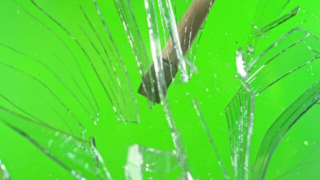Super slow motion of glass-breaking hammer, shattering against green screen background . Filmed on high speed cinema camera, 1000 fps .