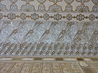 The mirror mosaic ceiling in Amer Fort showcases a mesmerizing arrangement of mirrors, resulting in a breathtaking exhibition of luminosity and reflection.