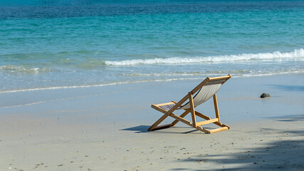 Wooden beach chairs with empty sand, beach with bright blue sea in summer, holiday, copy space for...