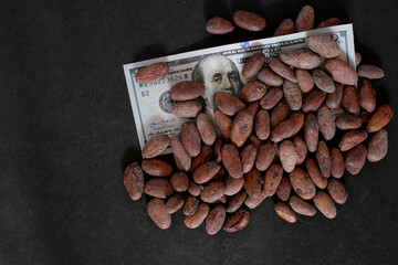 Cocoa beans on a black background. United States Dollar or American Dollar. The price of cocoa...