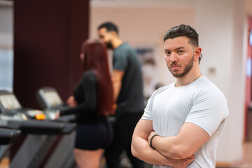  Serious men looking gym goer standing with arms crossed in a contemplative posture. 