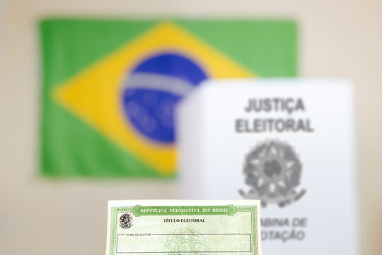 Destaque para o t&iacute;tulo de eleitor, essencial para votar nas elei&ccedil;&otilde;es do Brasil. No fundo, h&aacute; uma cabine de vota&ccedil;&atilde;o da urna eletr&ocirc;nica e a bandeira do Brasil. Elei&ccedil;&otilde;es e a democracria brasileira.
