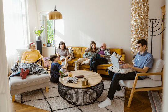 Multi-generation family enjoying while sitting together in living room at home