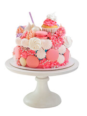Bright beautiful pink cake with golden fondant horn, twisted lollipops, macaroons and meringues on neutral background