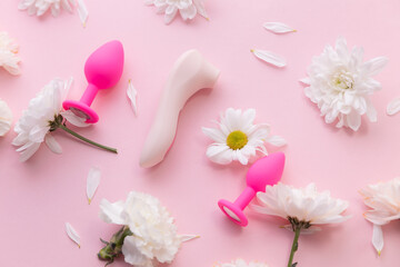Top view Different set sex toys for woman on pink background with flowers. Sexshop advertising banner - obrazy, fototapety, plakaty