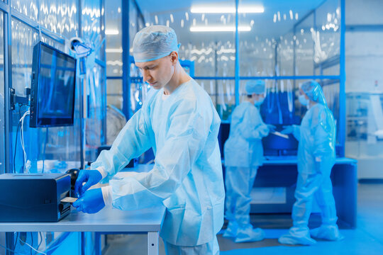 Worker in blue uniform control production scanning surgery kit box in distribution storage of med factory