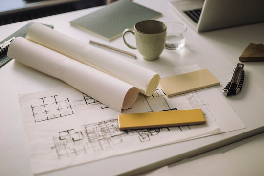 Rolled up blueprints with tools kept on desk at architect's office