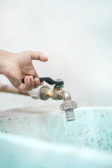 mano de un joven niño caucasico de 2 años abriendo la llave de agua 