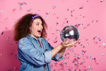 Photo of impressed funky lady dressed jeans outfit catching disco ball empty space isolated pink color background - obrazy, fototapety, plakaty