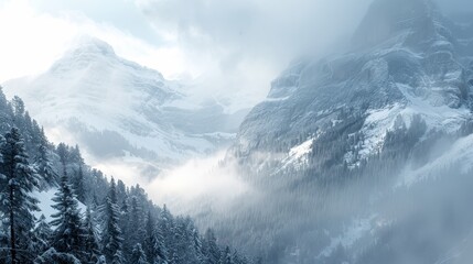 A mountain range covered in snow with a foggy mist in the air. The mountains are covered in snow and the sky is cloudy