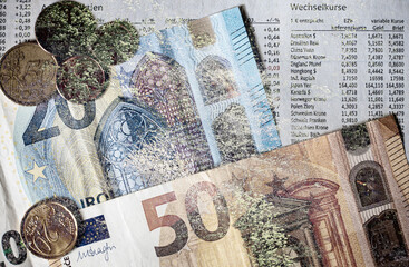 Mehrfachbelichtung von Wald, Geldscheinen, Münzen und Wechselkursen als Finanzkonzept.