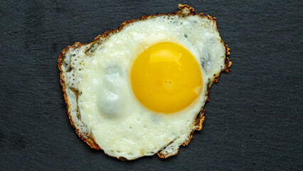 Fried egg on a cast iron frying pan, breakfast