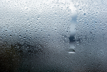 Image of cold tones of water droplets condensed on a glass