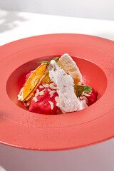 Summer dessert - berry sorbet with citrus and crispy waffles. Strawberry gelato on red ceramic plate. Frozen dessert from strawberry Homemade sorbet with citrus and fruit in restaurant plate