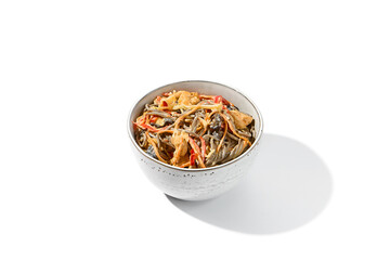 Asian fried buckwheat noodles with chicken in creamy garlic sauce isolated on white background. Japanese fried noodles in creamy sauce in ceramic bowl. Soba with chicken on wok in minimal style.