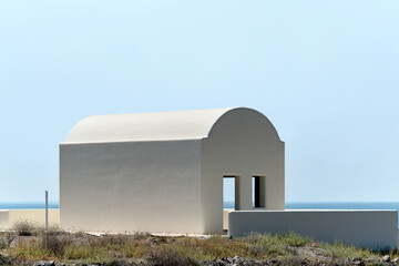 Traditional white house under construction with blue sky as background in Santorini, Greece