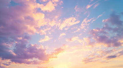 Naklejka na ściany i meble Pink and orange clouds illuminated by the setting sun against a soft blue sky