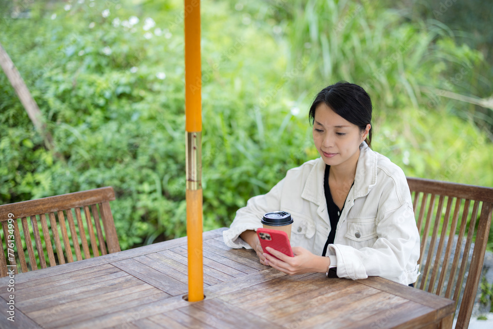 Wall mural Woman use of mobile phone in outdoor cafe