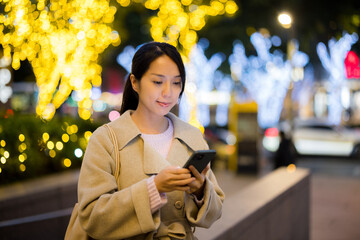 Woman hold with smart phone in Taipei city at evening time - 776135391