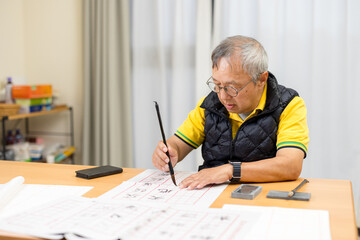 Asian old man practice Chinese calligraphy character at home - 776135566