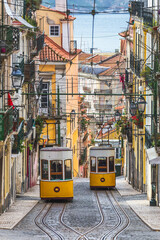Traditional yellow trams, funicular on a street in Barrio Alto, Lisbon, Portugal