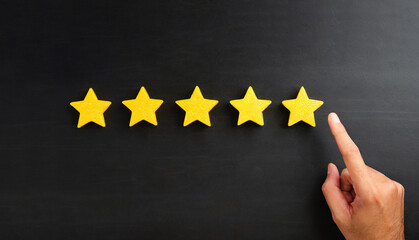 The best rating. Customer experience concept. Hand showing on five star excellent rating on black...