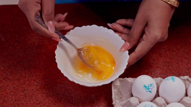 close up of hands holding a bowl of eggs 
Woman's hands close-up mixing eggs 