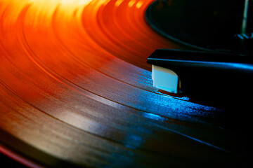 Close up photo of analog music player playing on turntable with needle illuminated in warm, cozy sunset light. Concept of art, retro music, vintage, disco, nostalgy, old-fashion. Ad