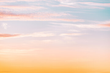 A beautiful sky tinted by the sun leaving vibrant shades of gold, pink, blue and multicolored. Clouds in the twilight evening and morning sky. Cloudy sky background in the evening and during the day.